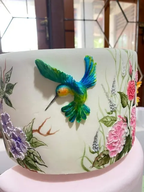Sculpted hummingbird on painted cake