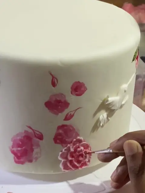 Hand-painting flowers on a cake
